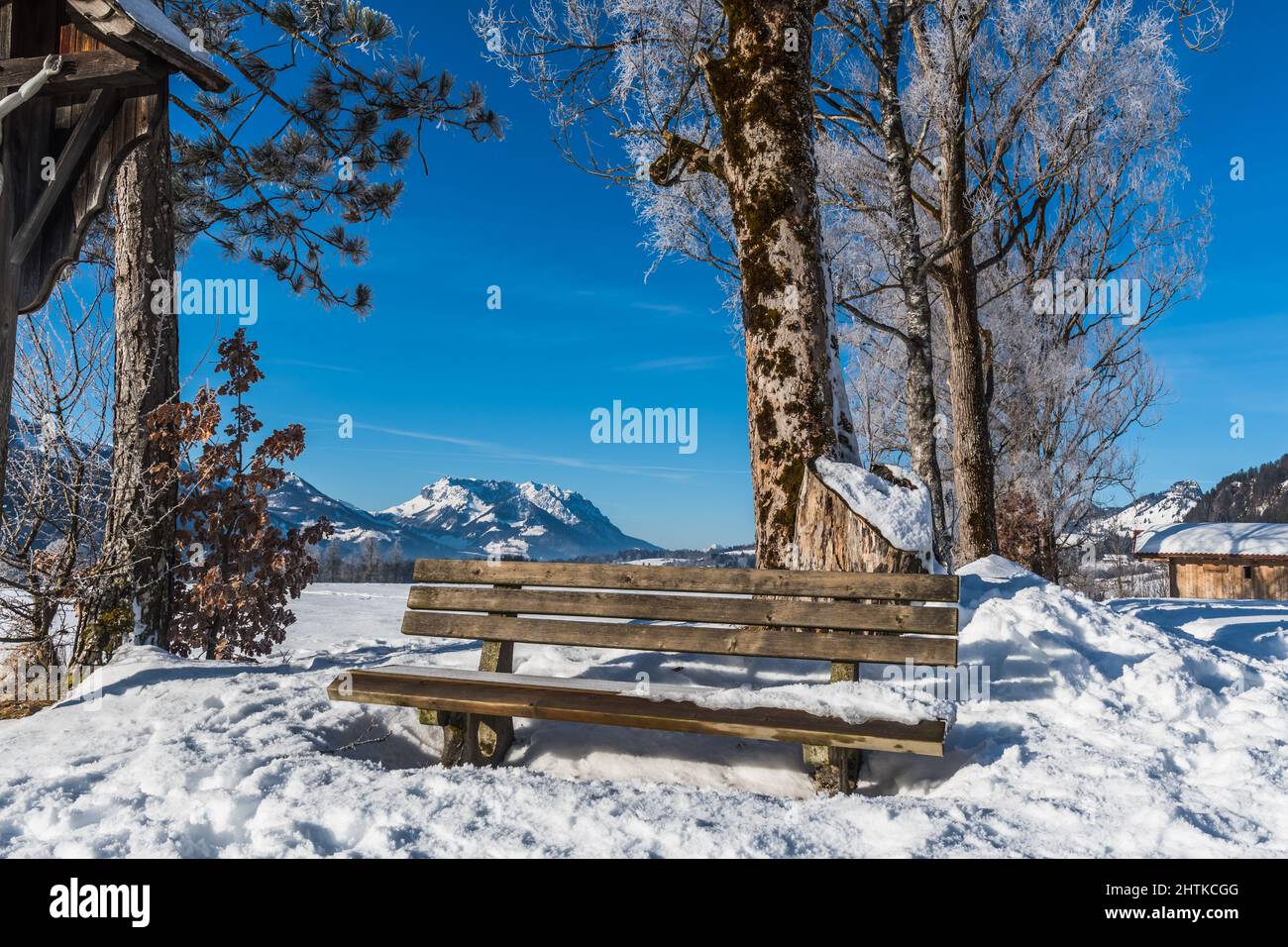 Bank in einer verschneiten Landschaft an einem sonnigen Wintermorgen Stockfoto
