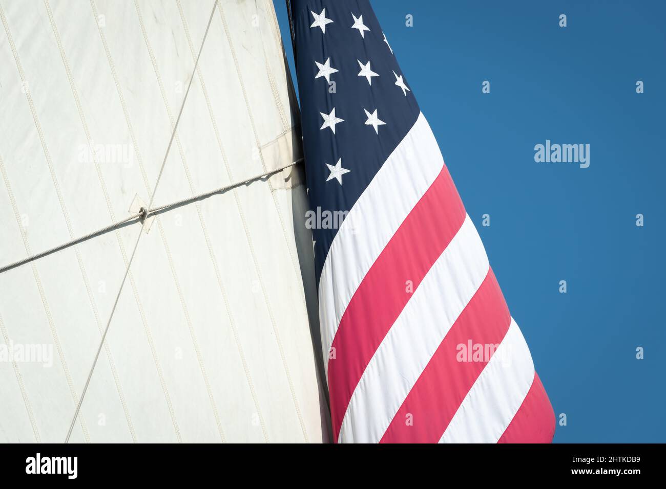 Große amerikanische Flagge hängt neben dem Mizzensegel auf einem amerikanischen Hochschiff. Stockfoto