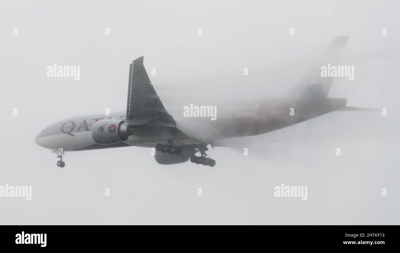 SeaTac, WA, USA - 28. Februar 2022; Qatar Airways Boeing 777 landet in SeaTac bei sehr starkem Regen, wobei Wasser aus den Flügeln strömt, wenn es sich endgültig nähert Stockfoto