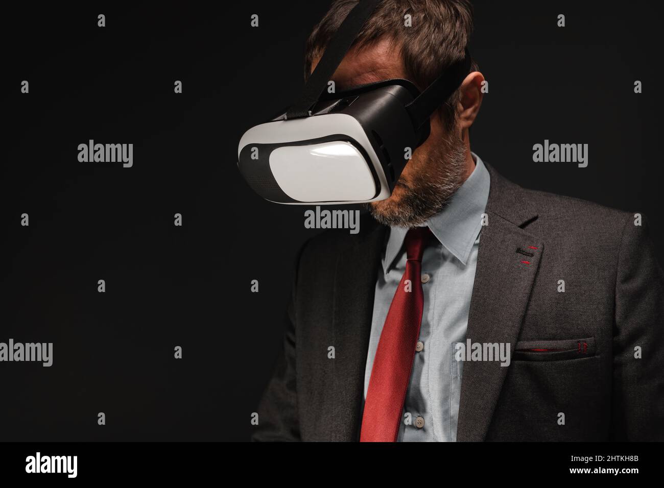 Geschäftsmann mit VR-Headset-Brille in dunklem Büroinnenraum, unauffingeres Porträt mit selektivem Fokus Stockfoto