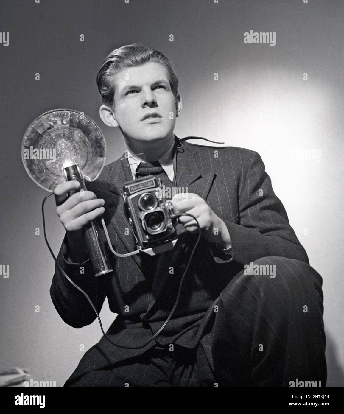Pressefotograf der 1940s. Anders Swahn zeigte sich mit einer Rolleiflex-Kamera und einem tragbaren Blitzgerät. Eine Standardausstattung für Pressefotografen zu dieser Zeit. Schweden 1949 Kristoffersson Ref. AA40-4 Stockfoto