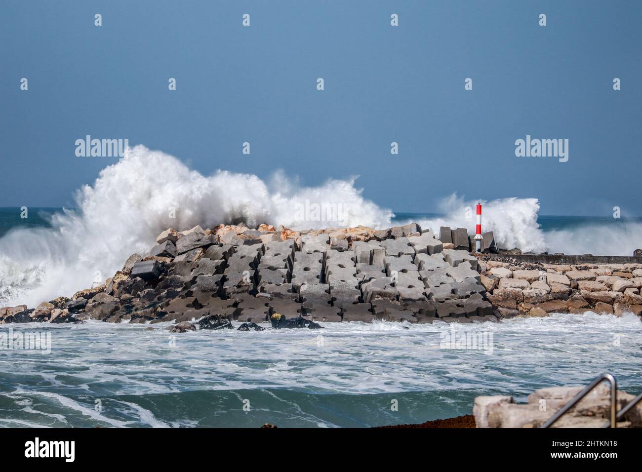 An einem stürmischen Tag traf von einem Pier aus eine große Meereswelle in einem Steg ein Stockfoto