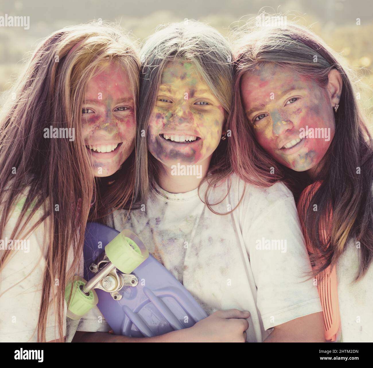 Verrückte Hipster Mädchen mit Penny Board. Sommerwetter. Positiv fröhlich. Kinder mit kreativer Körperkunst. Bunte Neonfarbe Make-up. Frohe Jugend Stockfoto