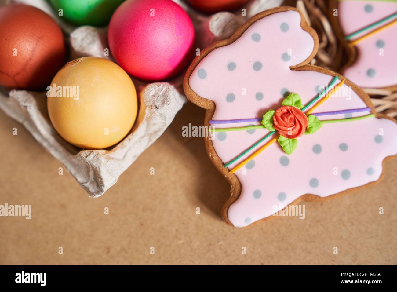 Ostereier und Lebkuchen in Form eines Hasen auf sandigen Hintergrund. Minimales Konzept.mit Platz zum Kopieren. Hochwertige Fotos Stockfoto