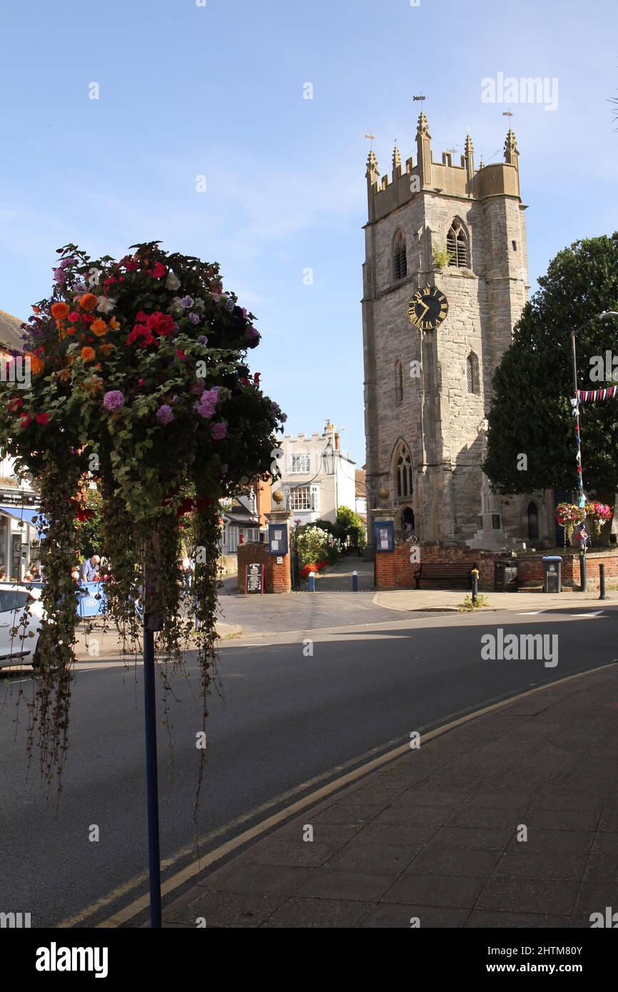 St. Nichola Church and Tower, in Shakespeare Country, Alcester, Warwickshire, Großbritannien. Mit blauem Sommerhimmel und einem hängenden Korb im Vordergrund Stockfoto