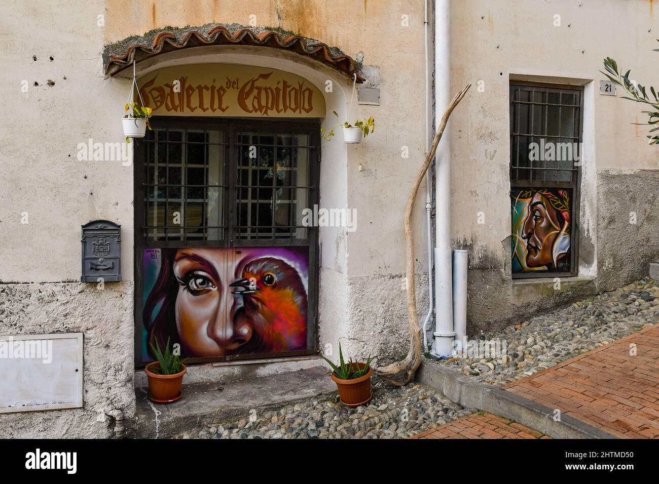 Außenansicht einer Werkstatt mit farbenfroher Malerei in einer bergauf führenden Gasse des mittelalterlichen Stadtteils 'La Pigna' von Sanremo, Imperia, Ligurien, Italien Stockfoto