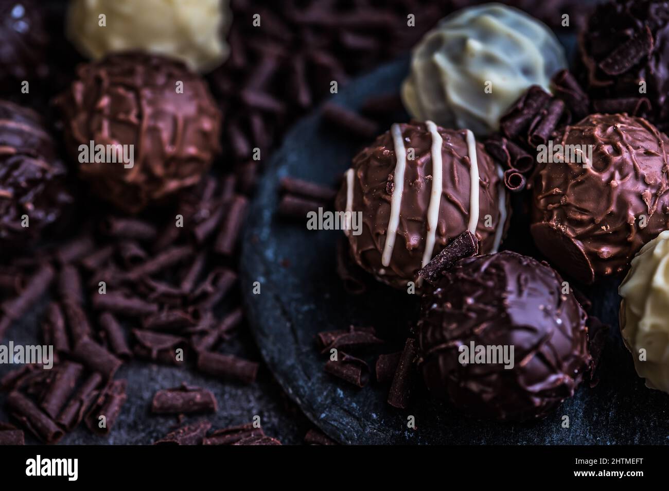 Schokoladentrüffel auf Schiefer, starker Kontrast Stockfoto