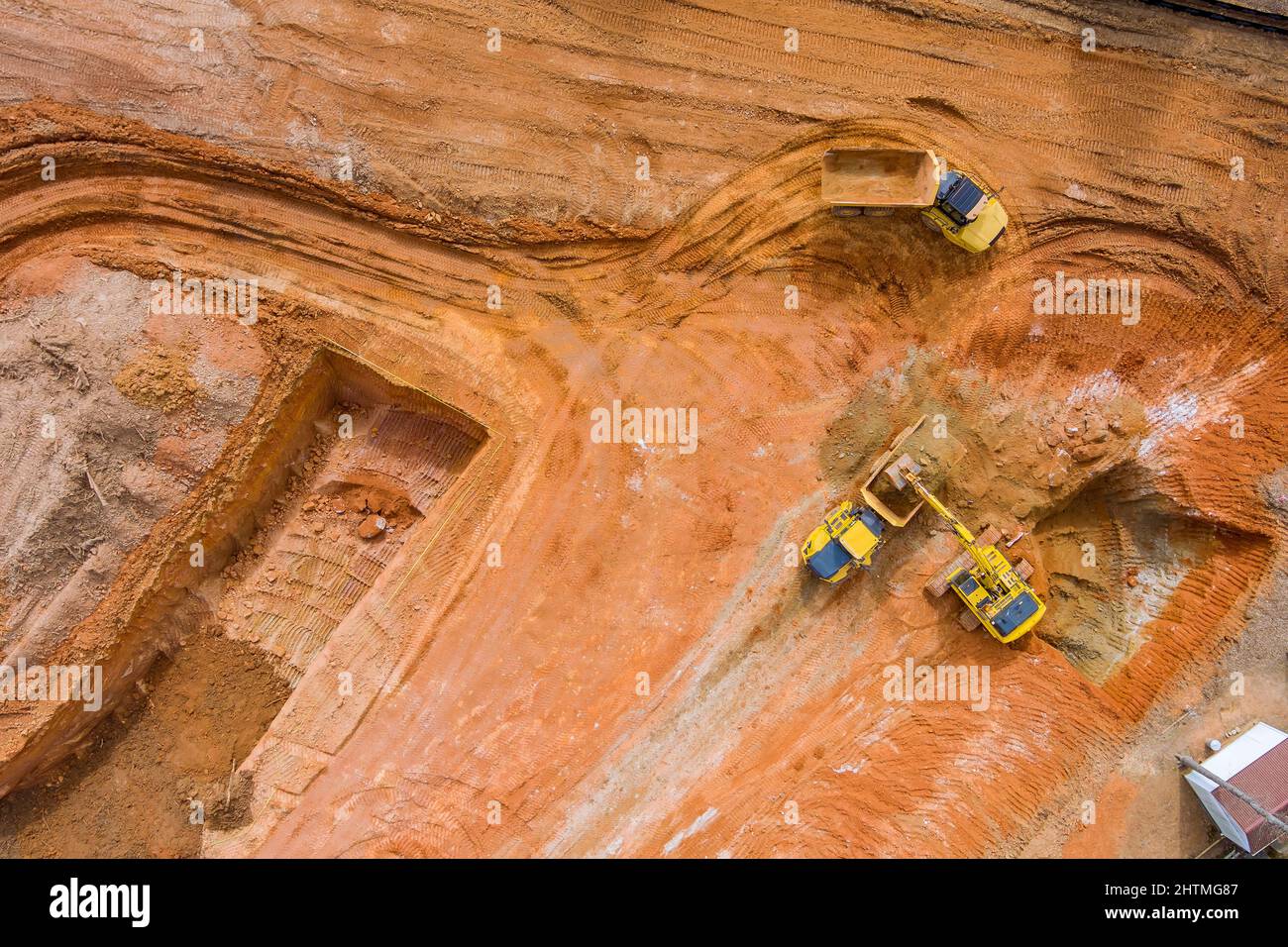 Luftaufnahme des Baggers, der den Kipper auf der Baustelle beladen hat Stockfoto