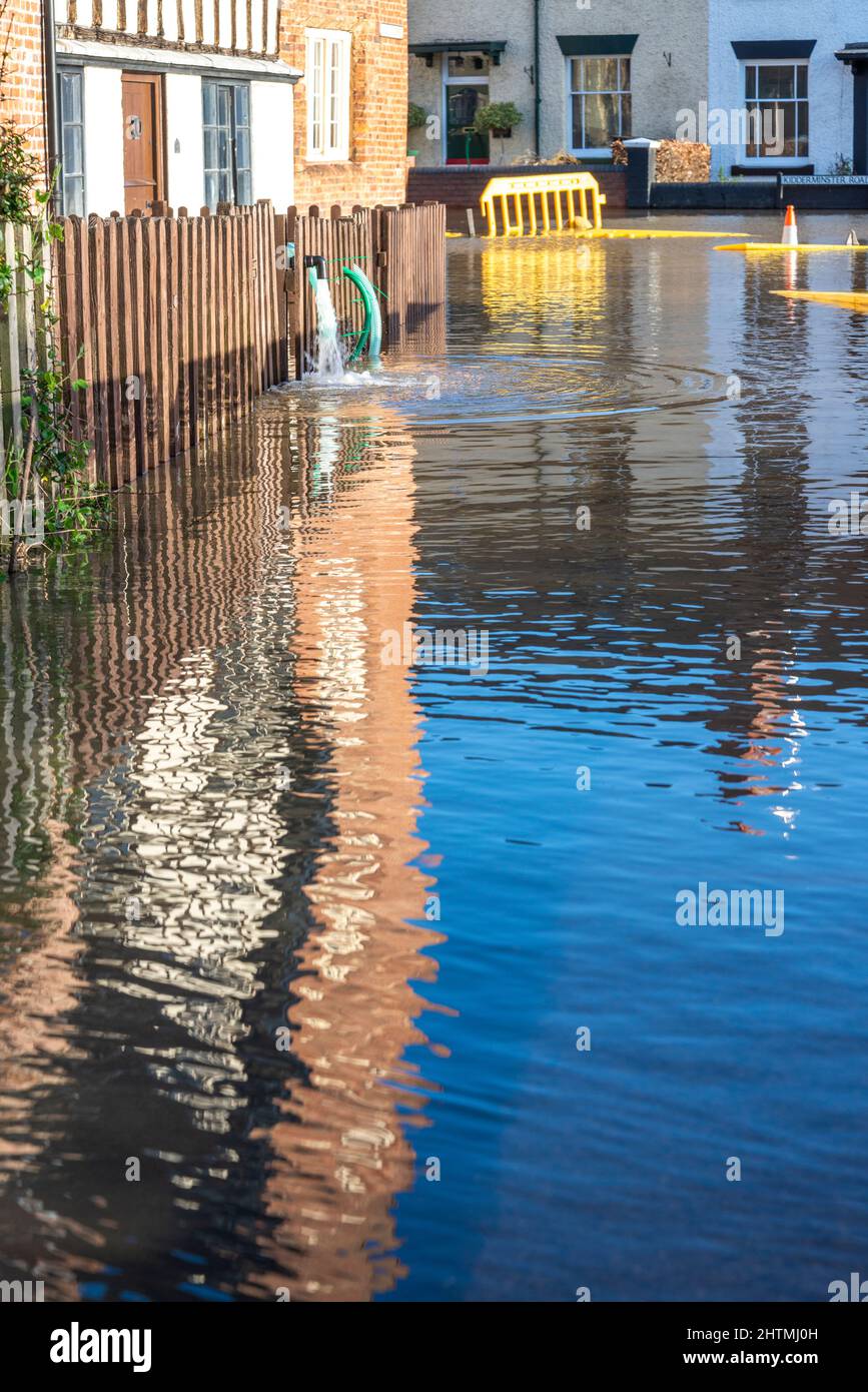 Das Überschwemmungswasser aus dem nahe gelegenen Fluss Severn muss aus den Häusern der Menschen in bereits überflutete Straßen gepumpt werden, was Chaos verursacht und durch Umweltklimmen verschlimmert wird Stockfoto