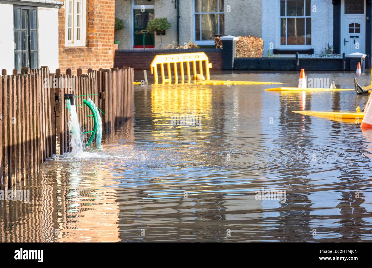 Das Überschwemmungswasser aus dem nahe gelegenen Fluss Severn muss aus den Häusern der Menschen in bereits überflutete Straßen gepumpt werden, was Chaos verursacht und durch Umweltklimmen verschlimmert wird Stockfoto