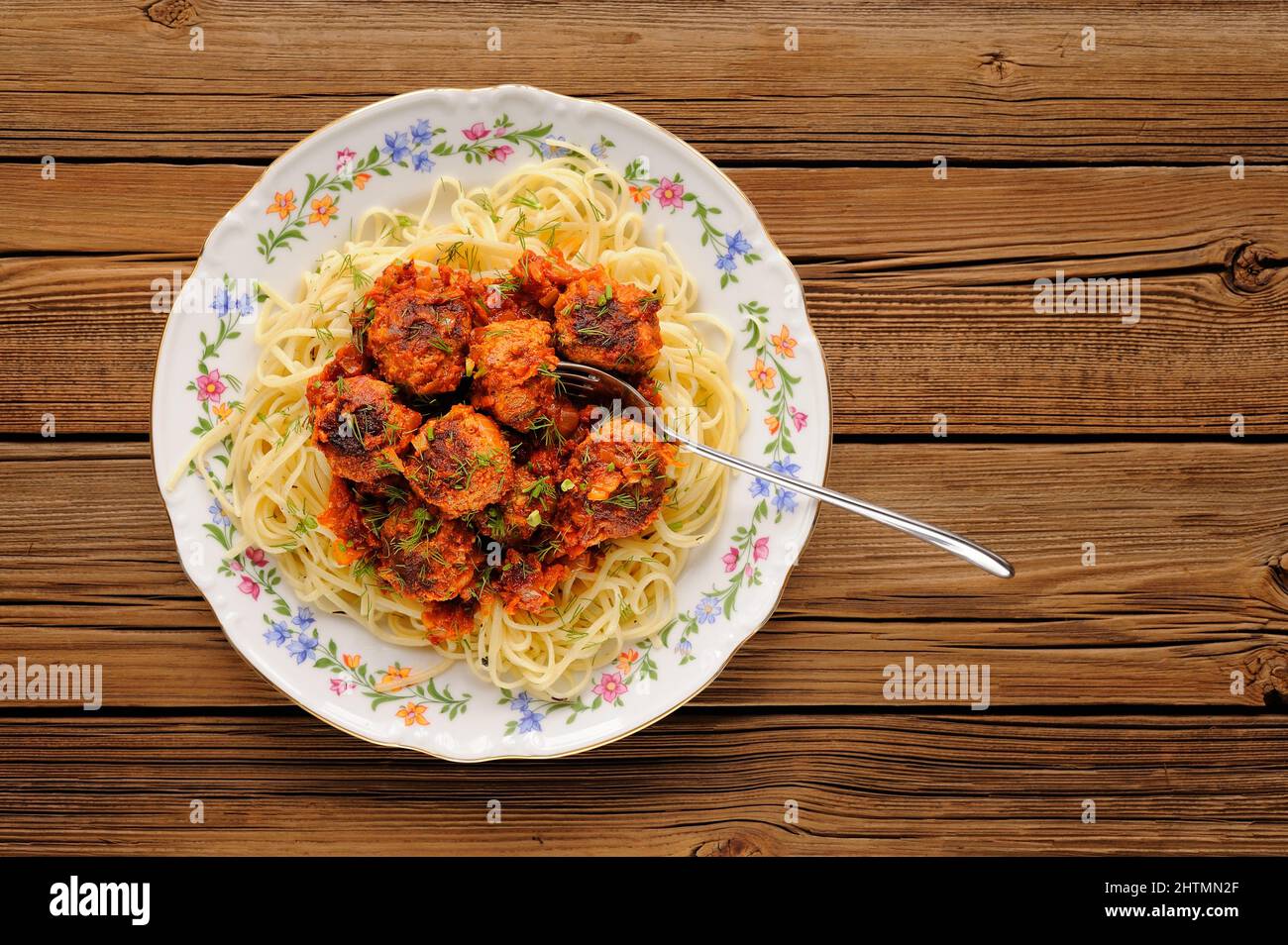 Spaghetti mit Fleischbällchen in Tomatensoße auf Holztisch, Blick von oben Stockfoto