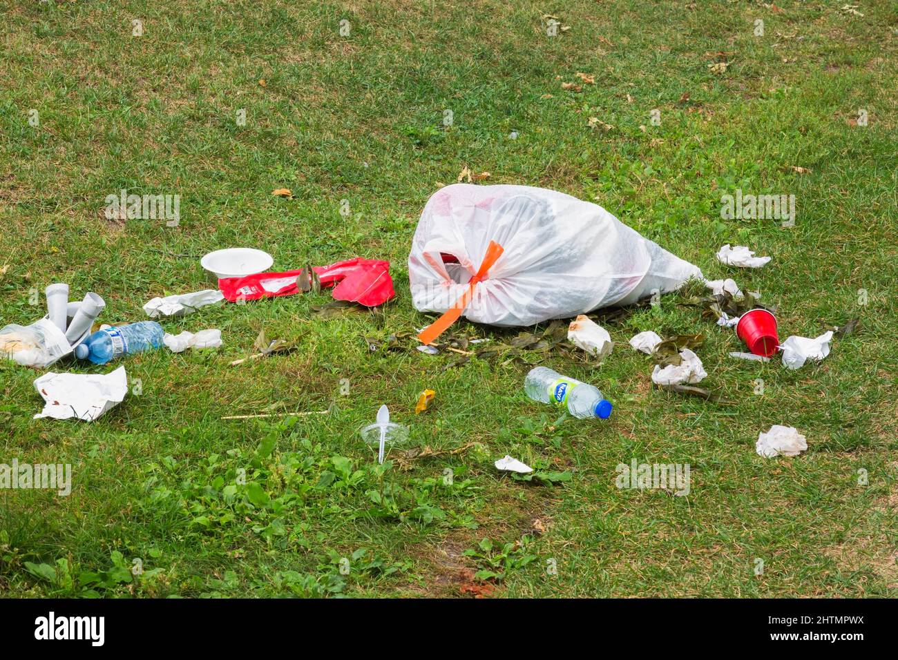 Recycelbarer Müll, der auf dem Rasen im öffentlichen Park weggeworfen wird. Stockfoto