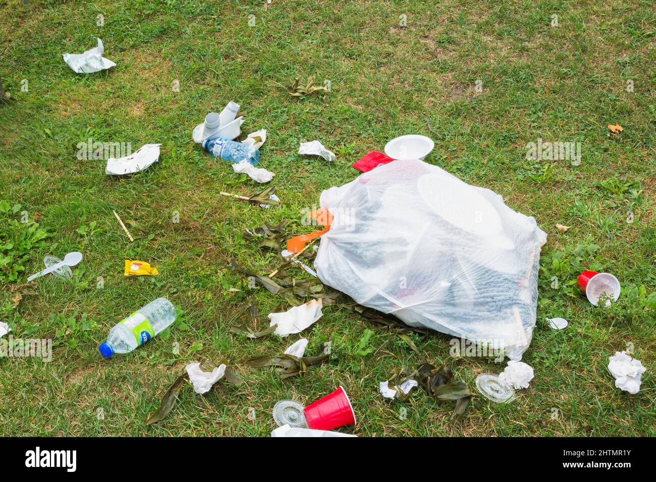 Recycelbarer Müll, der auf dem Rasen im öffentlichen Park weggeworfen wird. Stockfoto