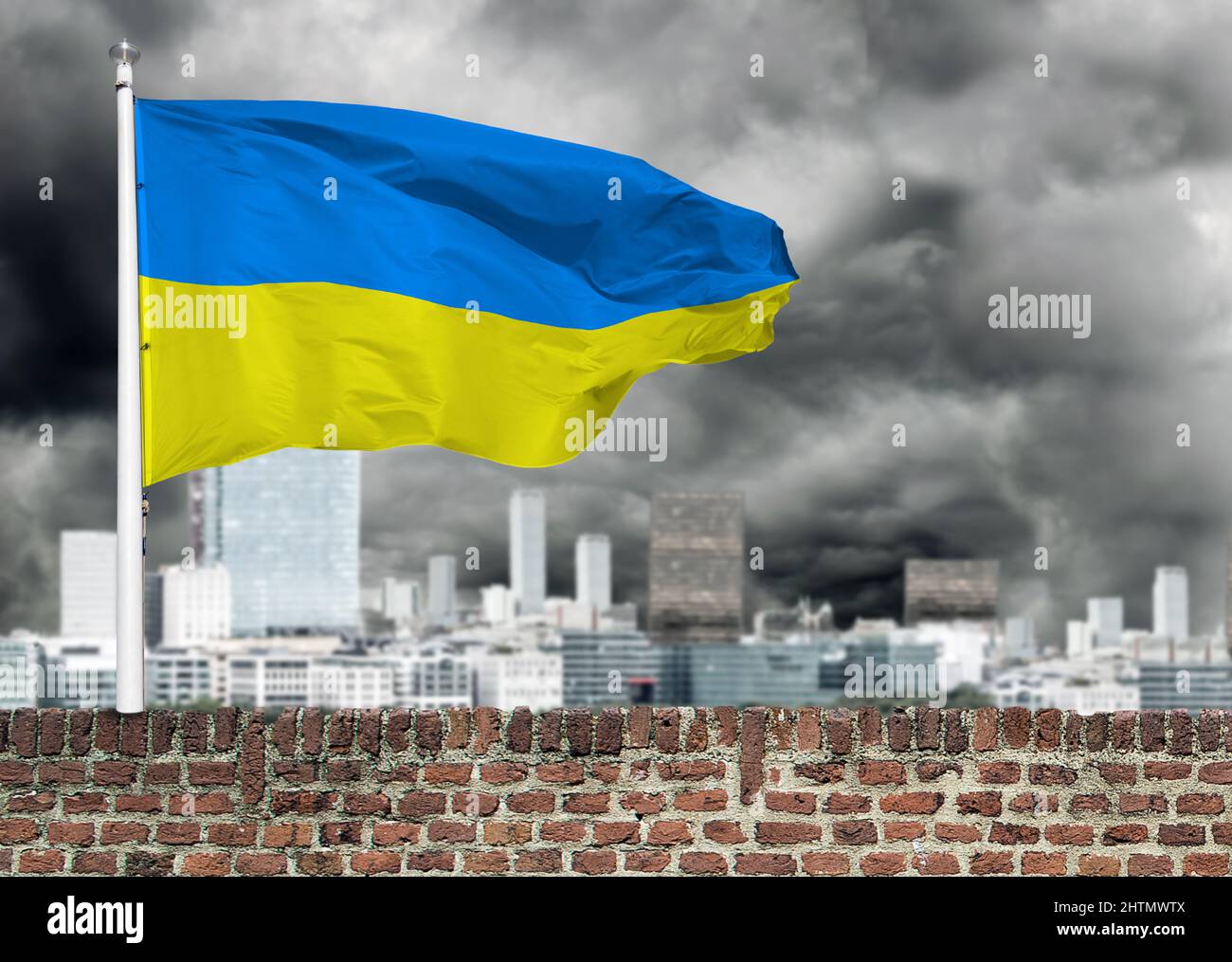 Ukrainische Flagge auf einer Ziegelmauer eines Gebäudes. Ukrainische Flagge am Himmel des Sturms schwarze Wolken. Stockfoto