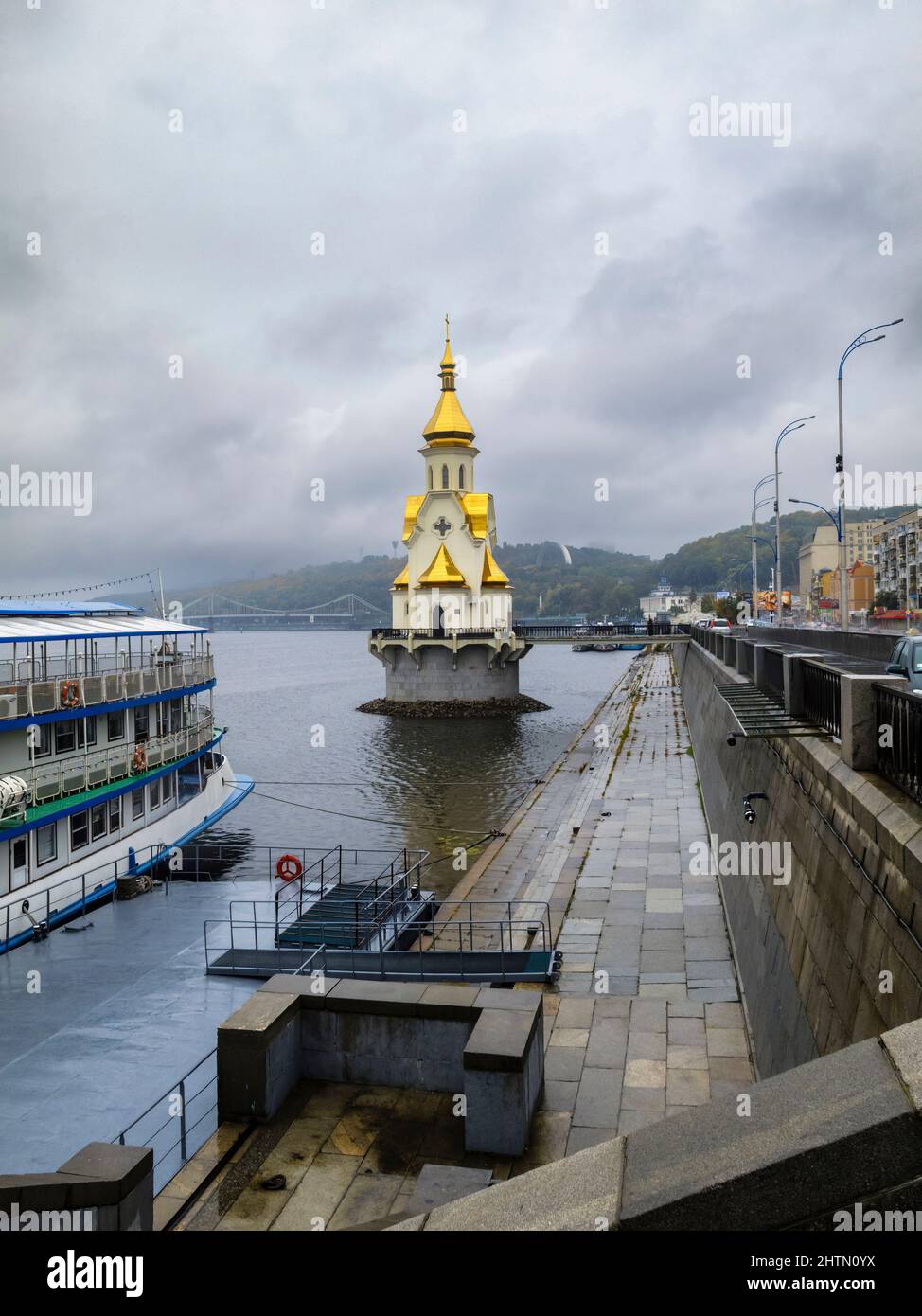 Die orthodoxe Kirche des heiligen Nikolaus des Wundertäters und die Uferpromenade am Dnjepr-Fluss im Bezirk Podil an einem nassen Tag, Kiew, Hauptstadt der Ukraine Stockfoto