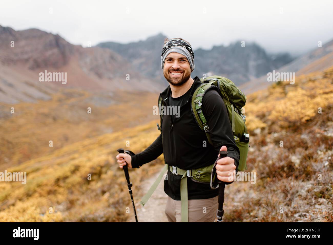 Kanada, Yukon, Whitehorse, Porträt eines lächelnden Wanderers in der Berglandschaft Stockfoto