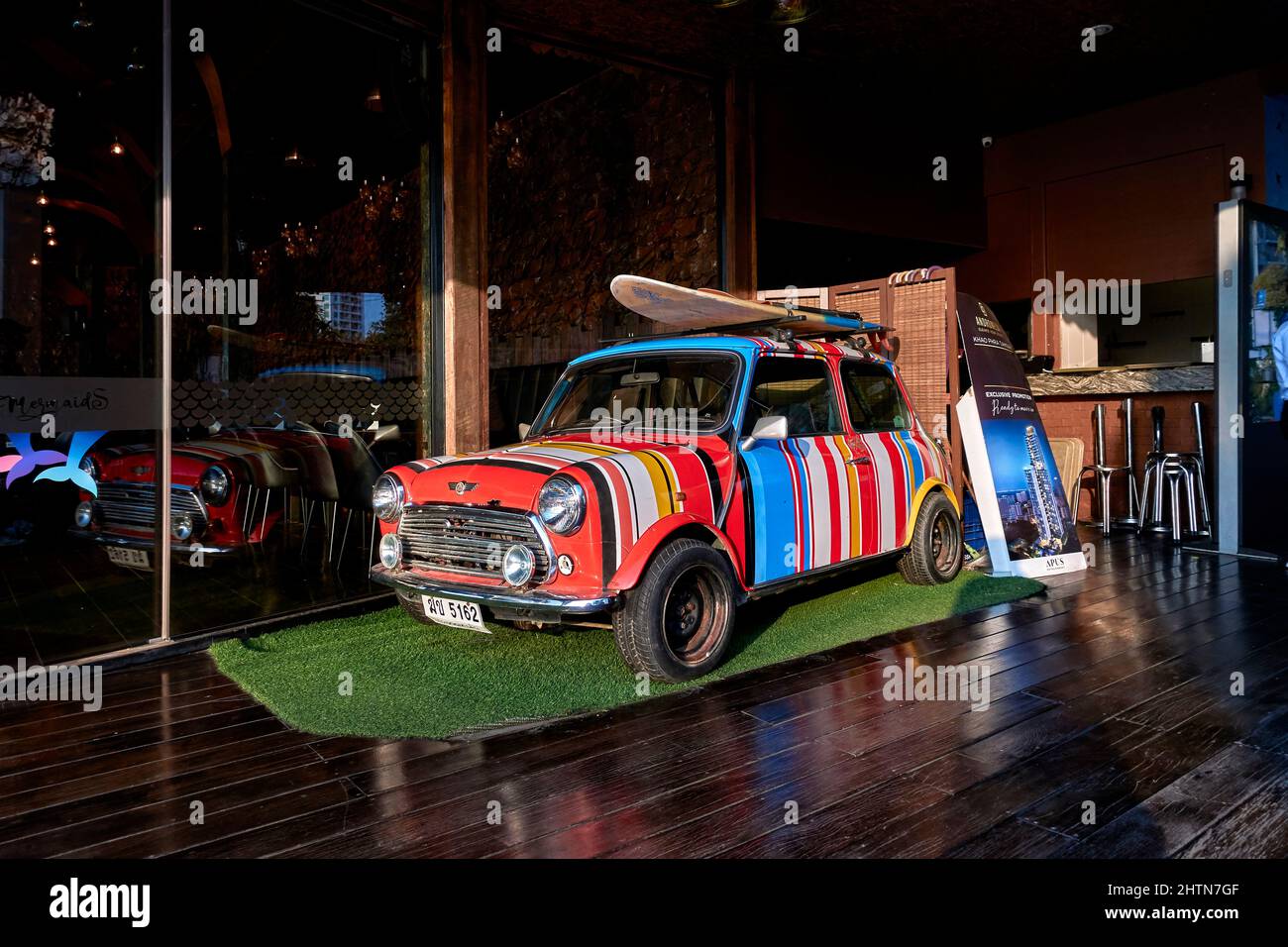 Paul Smith gestreifte Mini-Auto mit bunten Streifen mit Dach montiert Surfbrett lackiert. Fun Auto für junge Outdoor-Besitzer. Stockfoto