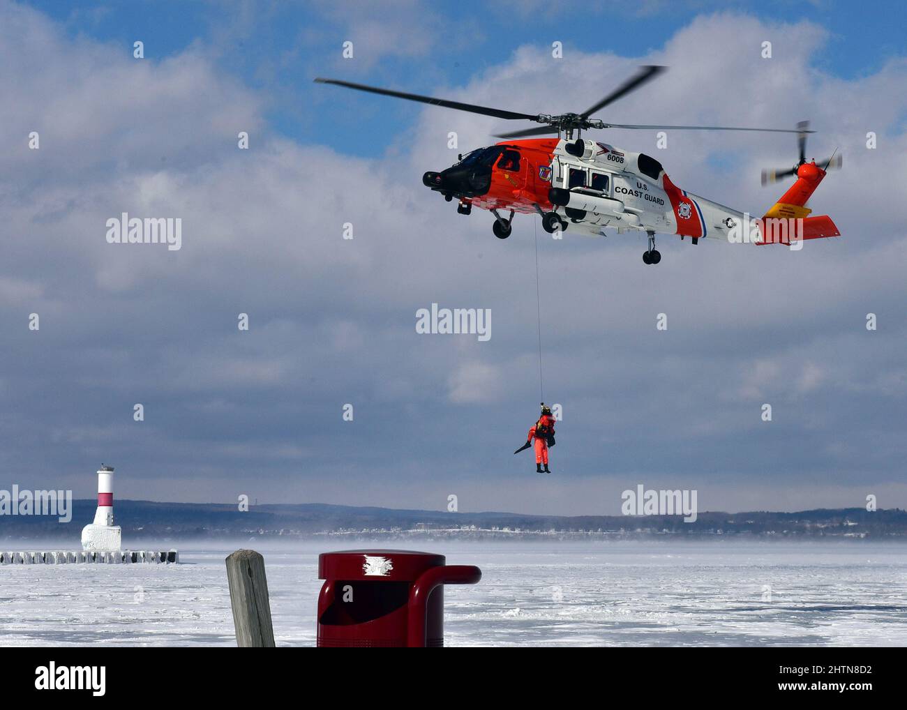 Petty Officer 3. Class James Lowen, ein Rettungsschwimmer der Air Station Traverse City, schweift einen simulierten Überlebenden direkt aus einem Loch im Eis während einer Masseneisrettungsübung am 26. Februar 2022 in der städtischen Marina von Petoskey. Die Übung, bei der der Absturz eines Pendlerflugzeugs auf dem gefrorenen Lake Michigan simuliert wurde, brachte mehr als 100 Ersthelfer und Mitglieder der Küstenwache aus dem gesamten Norden von Michigan zusammen. Foto der US-Küstenwache vom Chief Petty Officer John Masson. Stockfoto