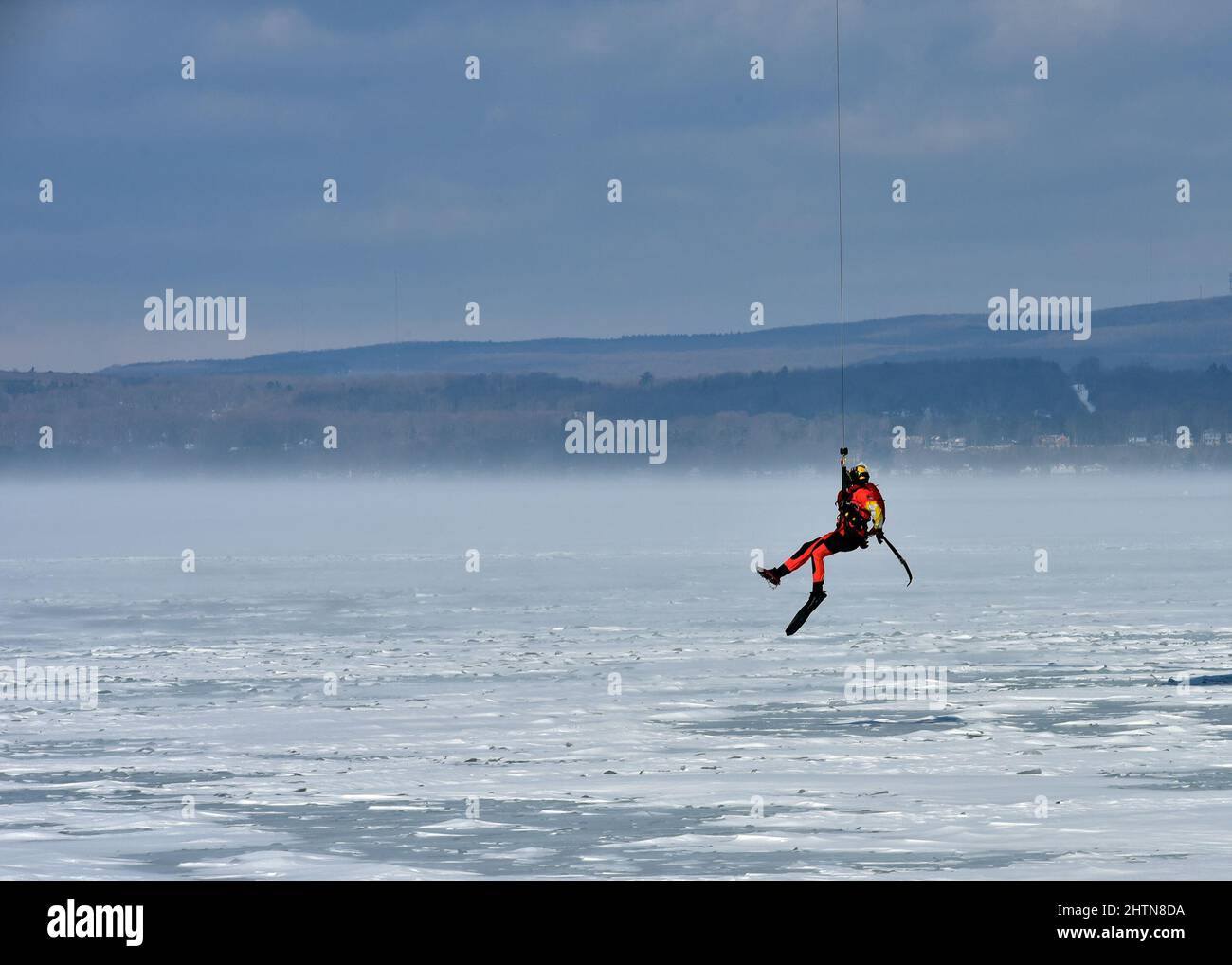 Petty Officer 3. Class James Lowen, ein Rettungsschwimmer der Air Station Traverse City, bereitet sich auf den Sprung auf einen gefrorenen Lake Michigan während einer großen Eisrettungsübung am 26. Februar 2022 in der Petoskey Municipal Marina vor. Die Übung, bei der der Absturz eines Pendlerflugzeugs in der Little Traverse Bay simuliert wurde, zog mehr als 100 Ersthelfer und Küstenwache-Mitglieder aus dem gesamten Norden von Michigan an. Foto der US-Küstenwache vom Chief Petty Officer John Masson. Stockfoto