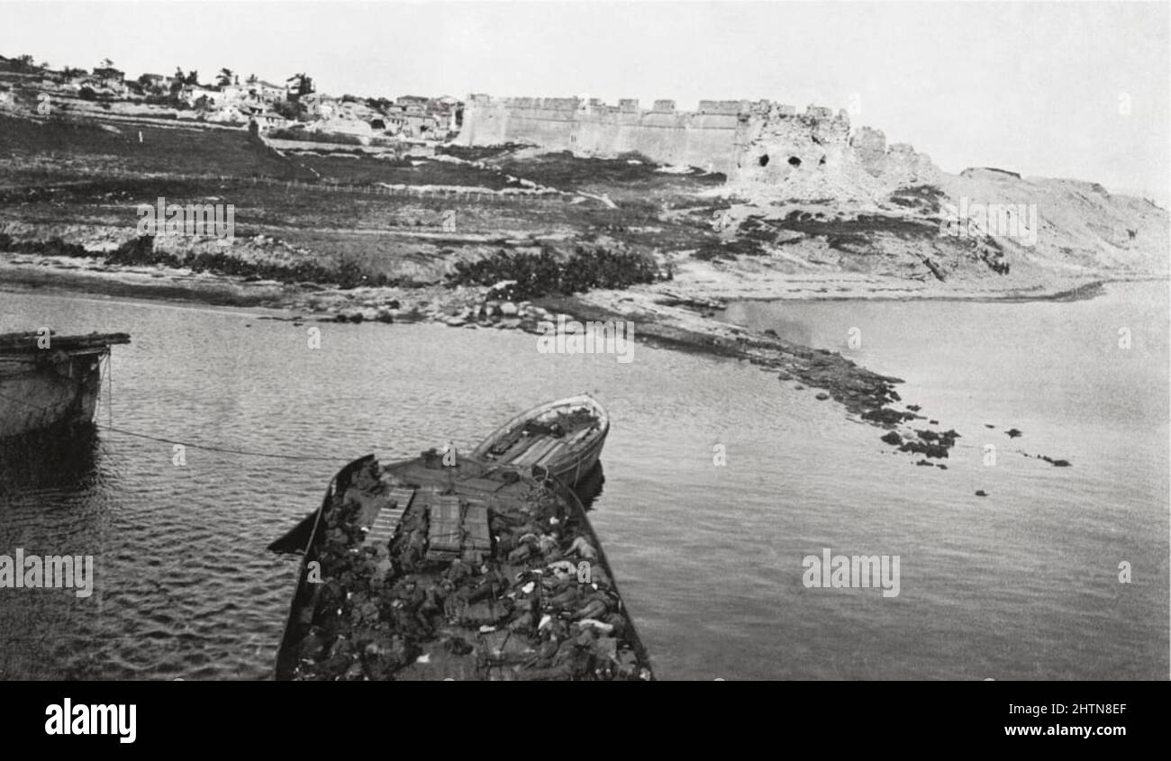 Sedd-el-Bahr Fort und Dorf vom SS-Fluss Clyde aus gesehen, 25. April 1915, während der Landung am Kap Helles, Schlacht von Gallipoli. Das Boot im Vordergrund enthält Tote der Royal Munster Fusiliers und des Hampshire Regiment, die bei dem Versuch, an Land zu kommen, getötet wurden. Stockfoto
