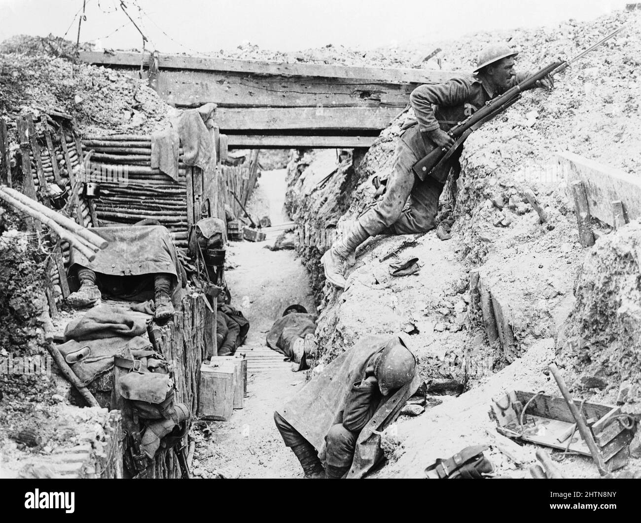Soldaten der „A“-Kompanie, des Bataillons von 11., des Regiments von Ceshire, besetzen einen gefangenen deutschen Graben bei Ovillers-la-Boisselle an der Somme. Auf diesem Foto hält ein Mann Wachdienst, schaut über die Paradiese und benutzt einen improvisierten Feuerschritt, der in den hinteren Hang des Grabens geschnitten ist, während seine Kameraden sich ausruhen. Stockfoto