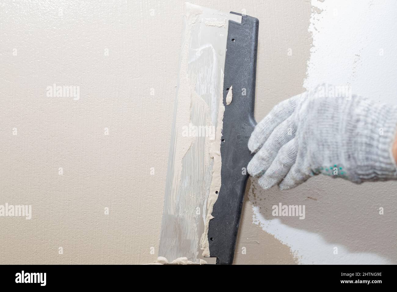 Mann verputzt Wand mit Kitt-Messer, Vorbereitung für die Malerei.Hände des  Arbeiters mit Wand verputzen Werkzeuge Haus renovieren. Putzer renovieren  Wände Stockfotografie - Alamy