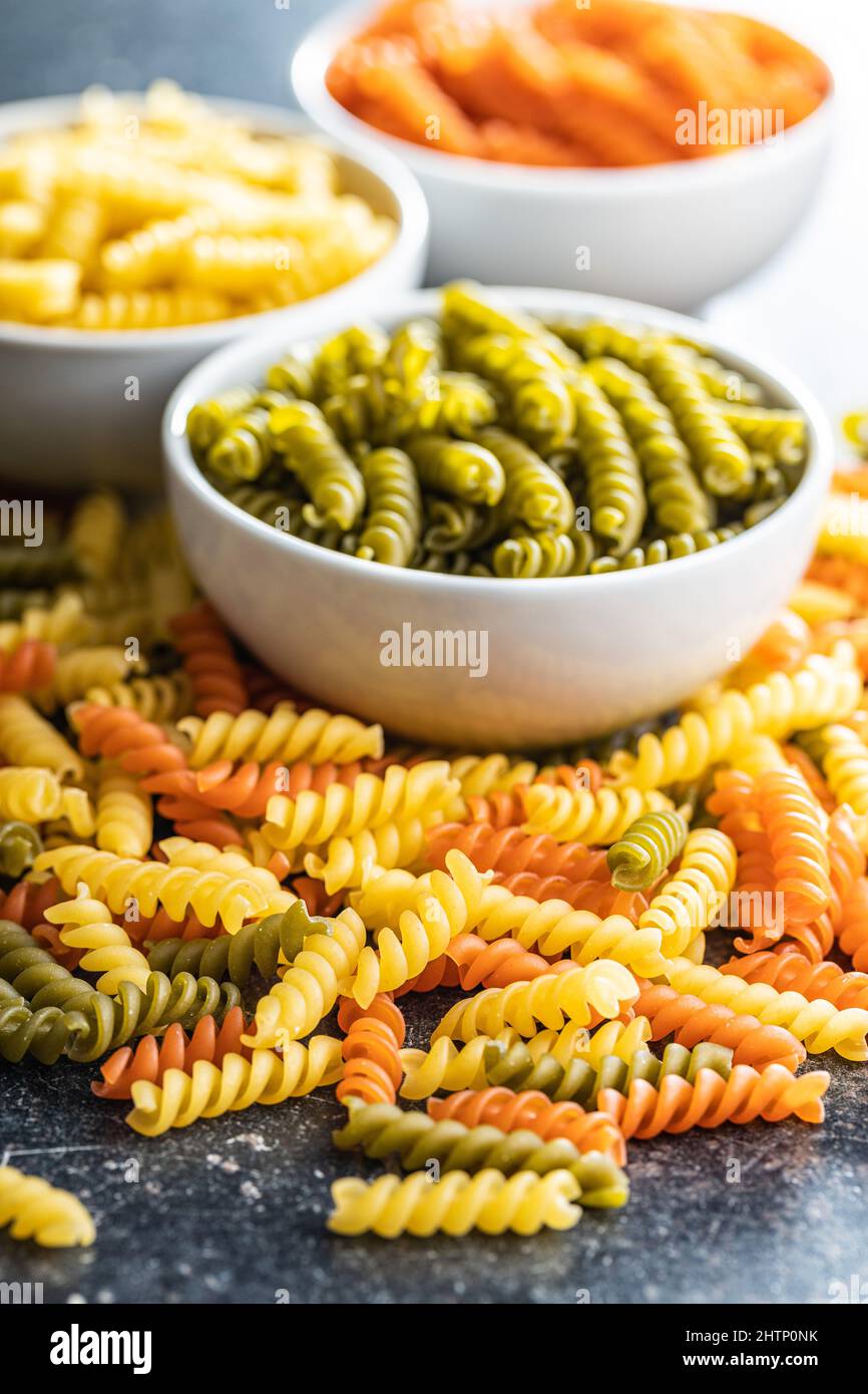 Drei Farben Fusilli Pasta. Bunte italienische rohe Pasta auf Küchentisch. Stockfoto
