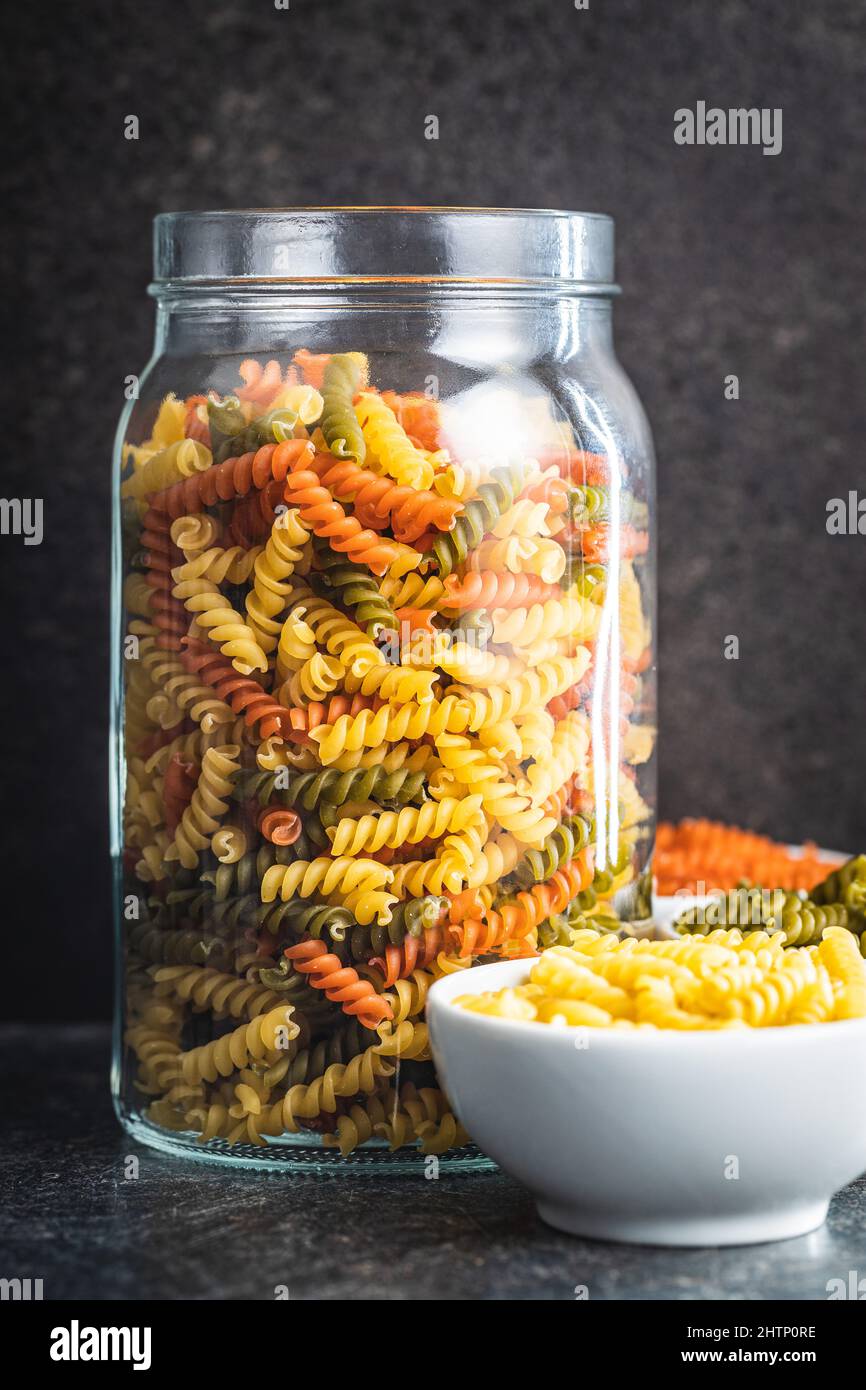 Drei Farben Fusilli Pasta. Bunte italienische rohe Pasta im Glas. Stockfoto