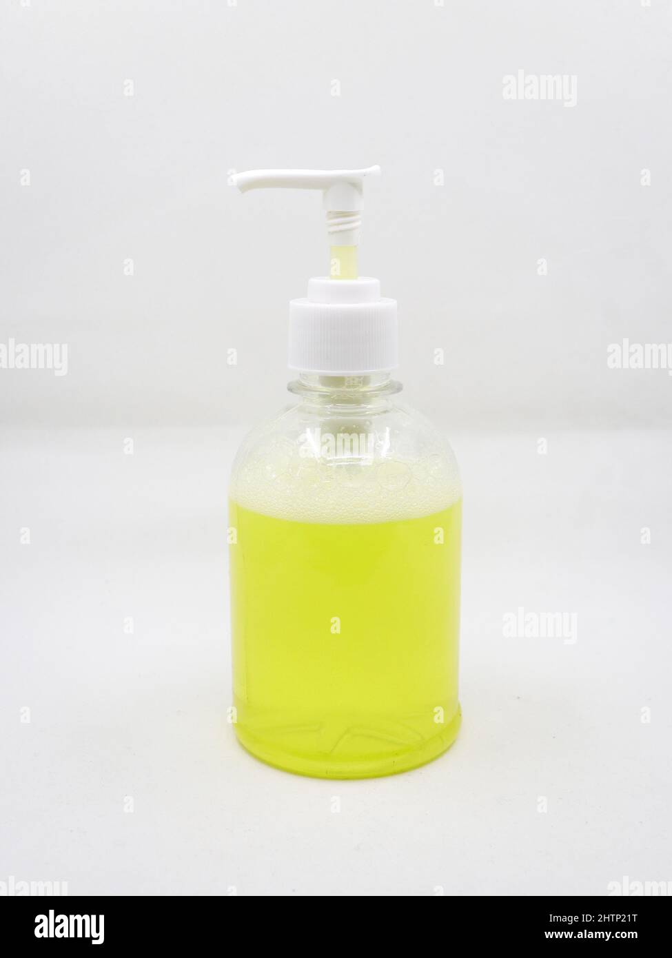Pressentyp Seifenspender mit gelber Seifenlösung zur Reinigung von Händen in Waschräumen isoliert auf weißem Hintergrund verwendet Stockfoto