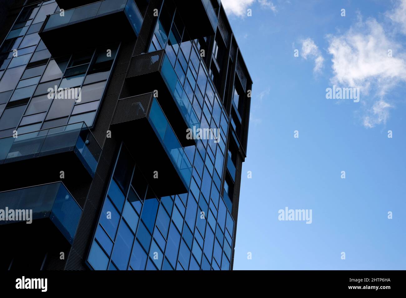 Dunkler Apartmentblock auf blauem Himmel Hintergrund Stockfoto
