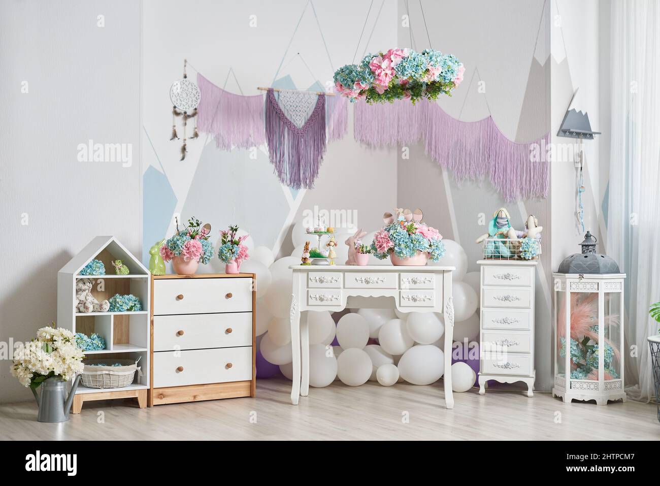 Kinder-Interieur mit Osterdekorationen, Spielzeug und Blumen Stockfoto