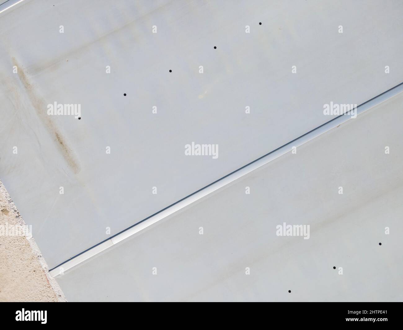 Drohnenflug über einen überdachten Pool mit einer Plane, die in einem Garten noch im Bau ist Stockfoto