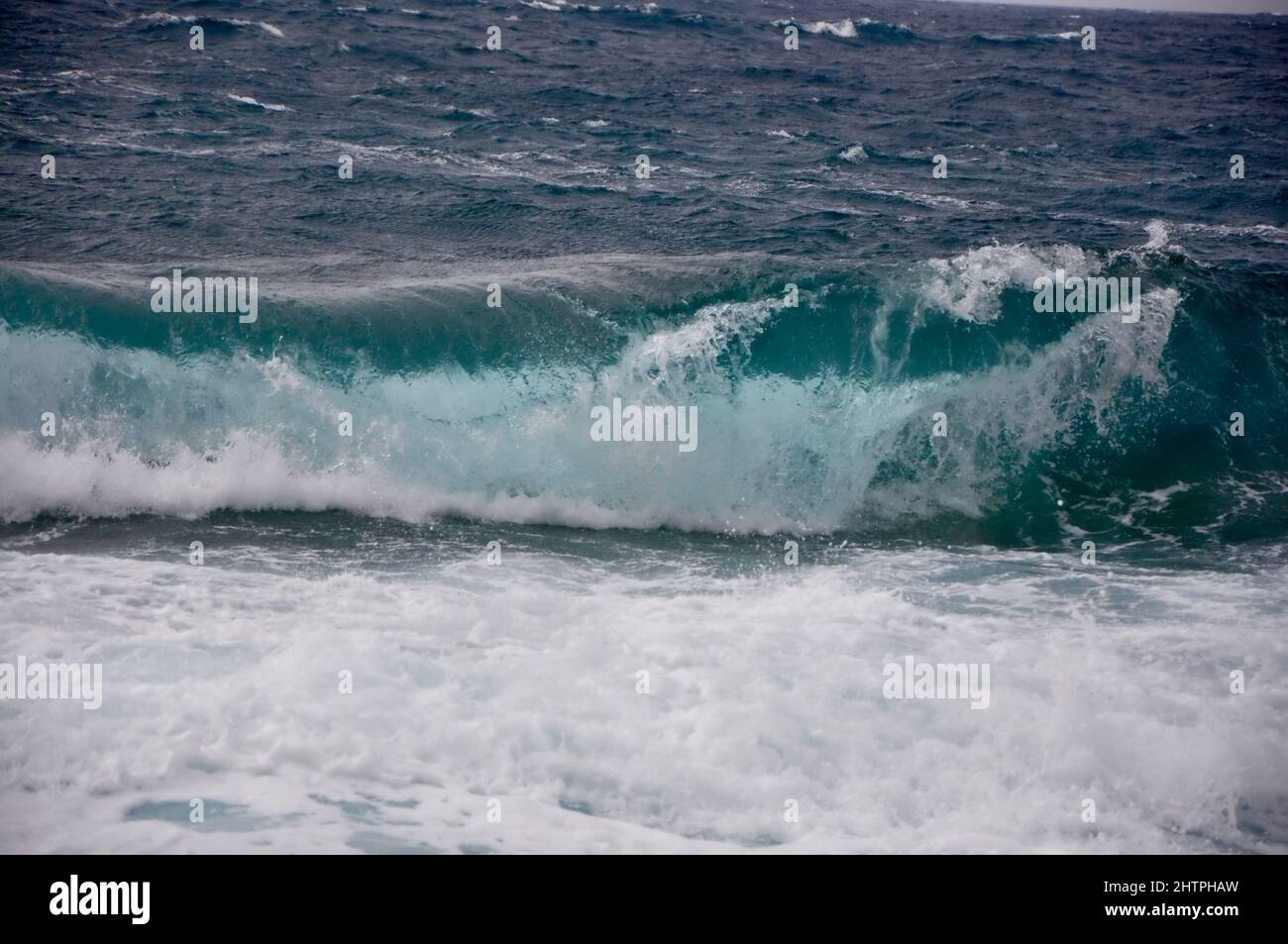 Eine große Welle überschneidet die Küste der kroatischen Insel Losinj. Rollende Welle stürzt an felsiger Küste ab. Stockfoto