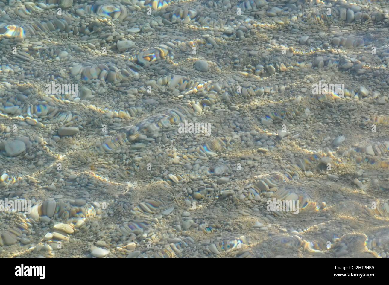 Klare Meerwasserstruktur. Unterwasser Meeressteine, Oberfläche Mit Wellen Und Wellen, Schönes Muster Transparentes Klares Wasser. Kieselsteine am Strand. Stockfoto