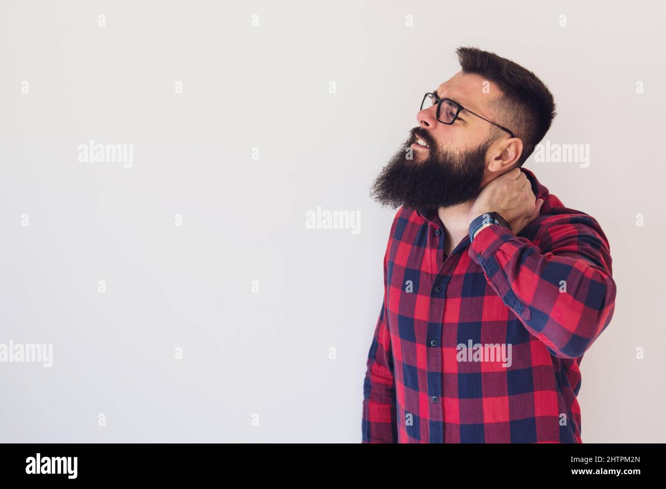 Porträt eines jungen Mannes, der Schmerzen im Nacken hat. Kopieren Sie Platz auf dem Bild für Ihren Text oder Ihre Anzeige. Stockfoto