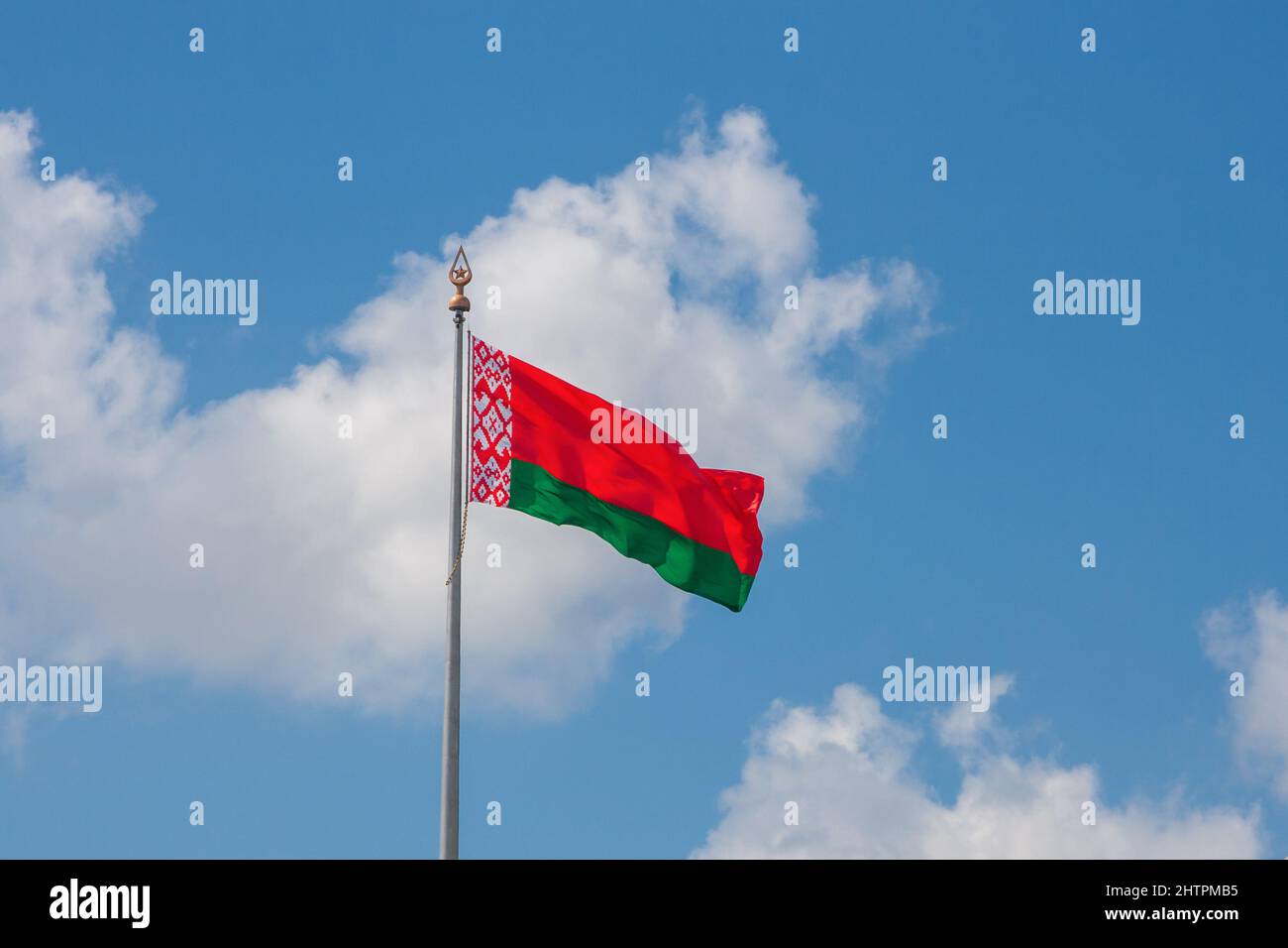 Die Flagge der Republik Weißrussland auf dem Hintergrund des blauen Himmels und der Wolken Stockfoto