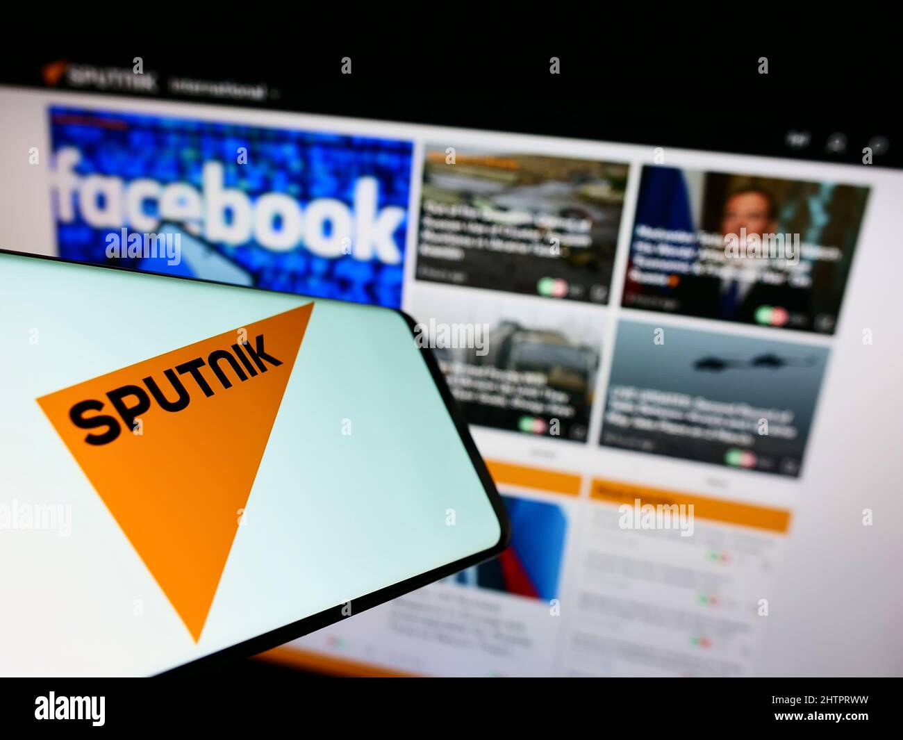 Handy mit Logo des russischen staatlichen Medienunternehmens Sputnik auf dem Bildschirm vor der Business-Website. Konzentrieren Sie sich auf die Mitte des Telefondisplays. Stockfoto