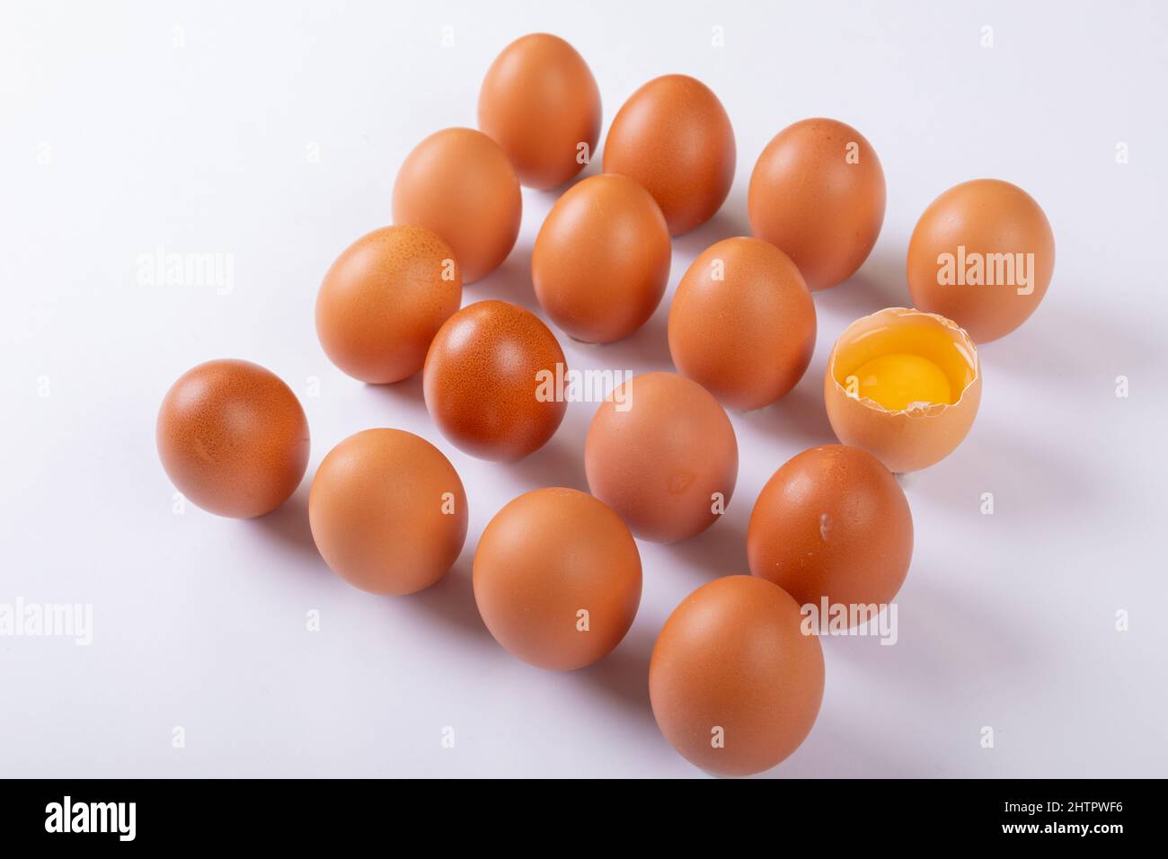 Blick auf braune Eier mit einem zerbrochenen Ei auf dem Tisch Stockfoto