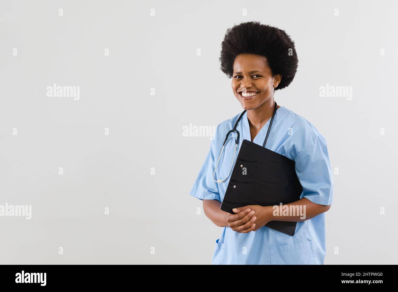 Porträt eines glücklichen afroamerikanischen Arzt für mittlere Erwachsene mit Zwischenablage auf weißem Hintergrund, Kopierraum Stockfoto