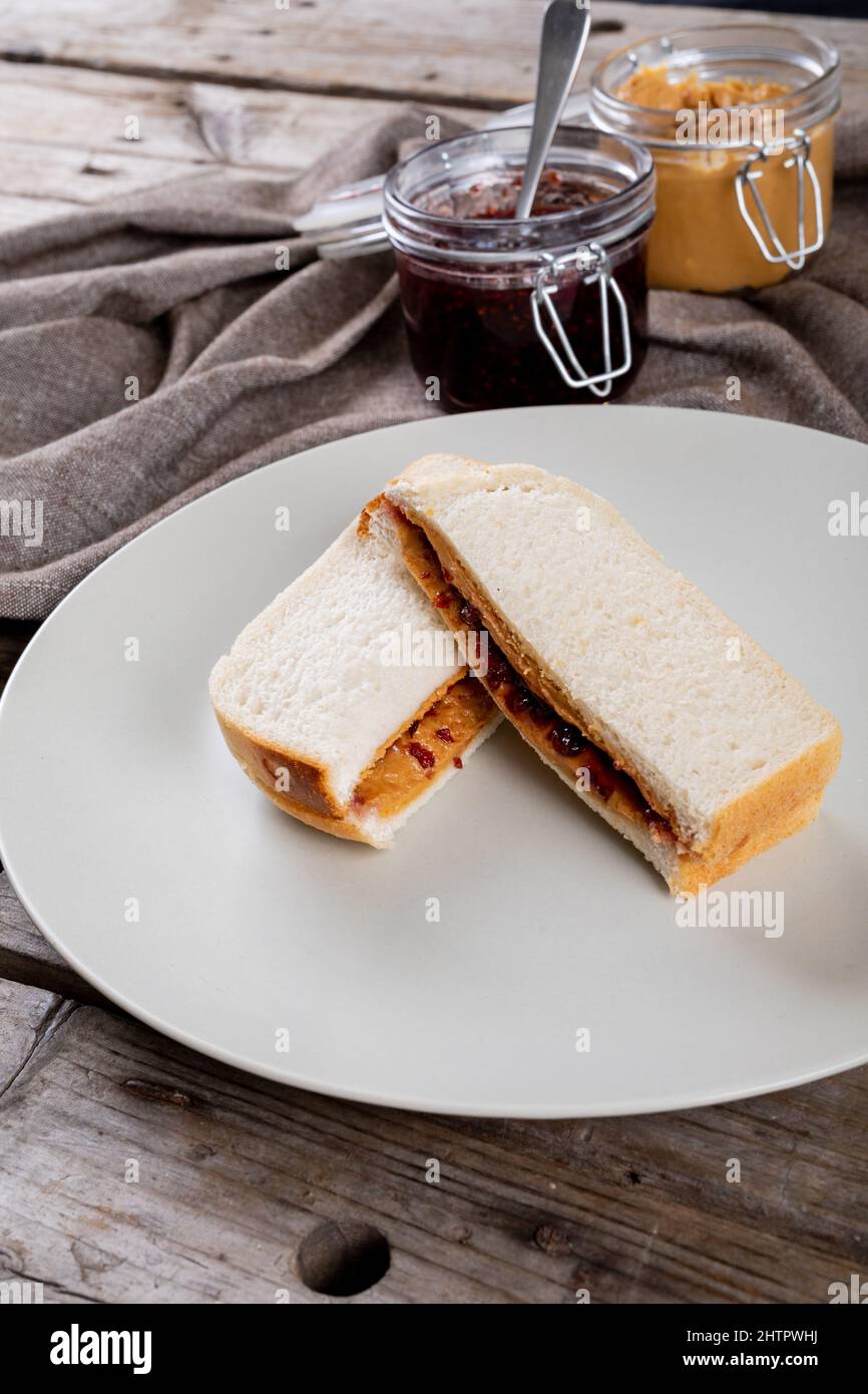 Nahaufnahme von Erdnussbutter und Gelee-Sandwich, serviert in Gläsern auf Serviette am Tisch Stockfoto