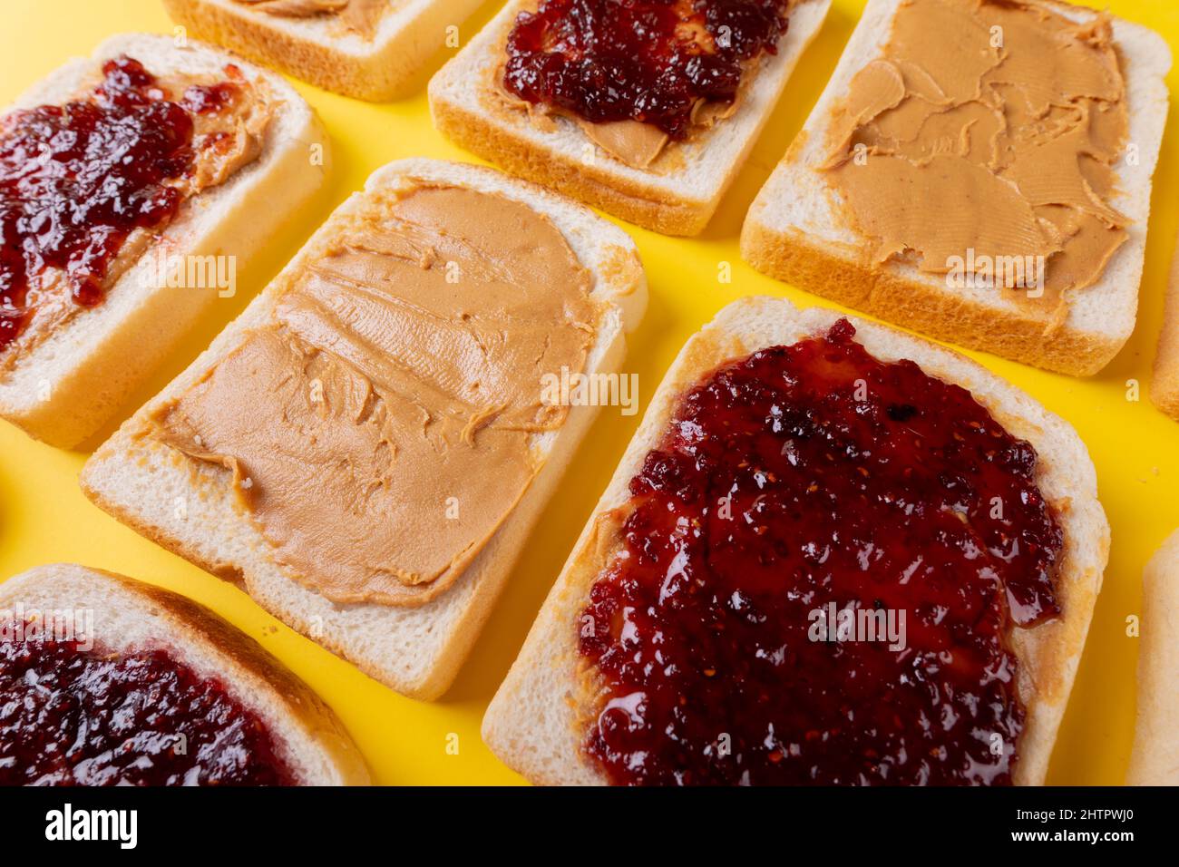 Eine Aufnahme von Brotscheiben mit Konserven und Erdnussbutter, die alternativ angeordnet sind Stockfoto