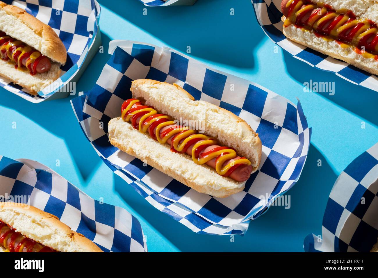 Nahaufnahme von Hot Dogs in Containern auf blauem Hintergrund Stockfoto