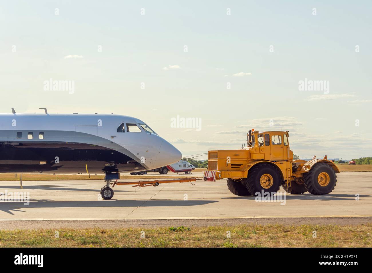 Das Flugzeug wird mit einem Flugzeugtraktor, Seitenansicht, nach hinten über den Rollfelsen geschoben Stockfoto