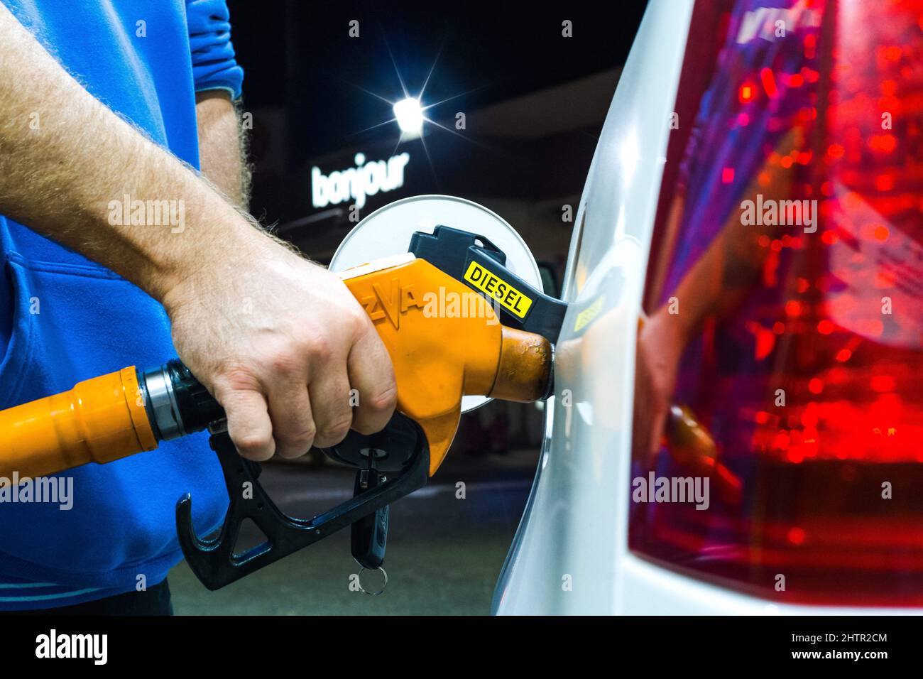 Frankreich, Montauban, 21. Oktober 2021. Ein Mann füllt sich mit Diesel in einer Totale-Tankstelle, mit einem beleuchteten Schild im Hintergrund, Hallo. Anstieg der Kraftstoffpreise in Frankreich, Nachtaufnahmen in Tankstellen. Foto von Patricia Huchot-Boissier/ABACAPRESS.COM Stockfoto