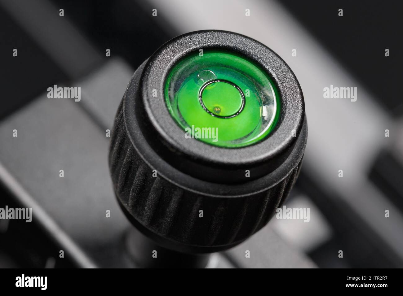 Die Luftblasenhöhe eines Fotostativs ist mit grüner Flüssigkeit gefüllt. Makrofotografie Stockfoto