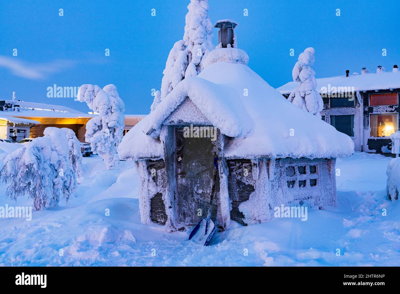 Gefrorene Blockhütte mit Schnee bedeckt in der Dämmerung während des kalten arktischen Winters, ISO-Syote, Lappland, Finnland Stockfoto