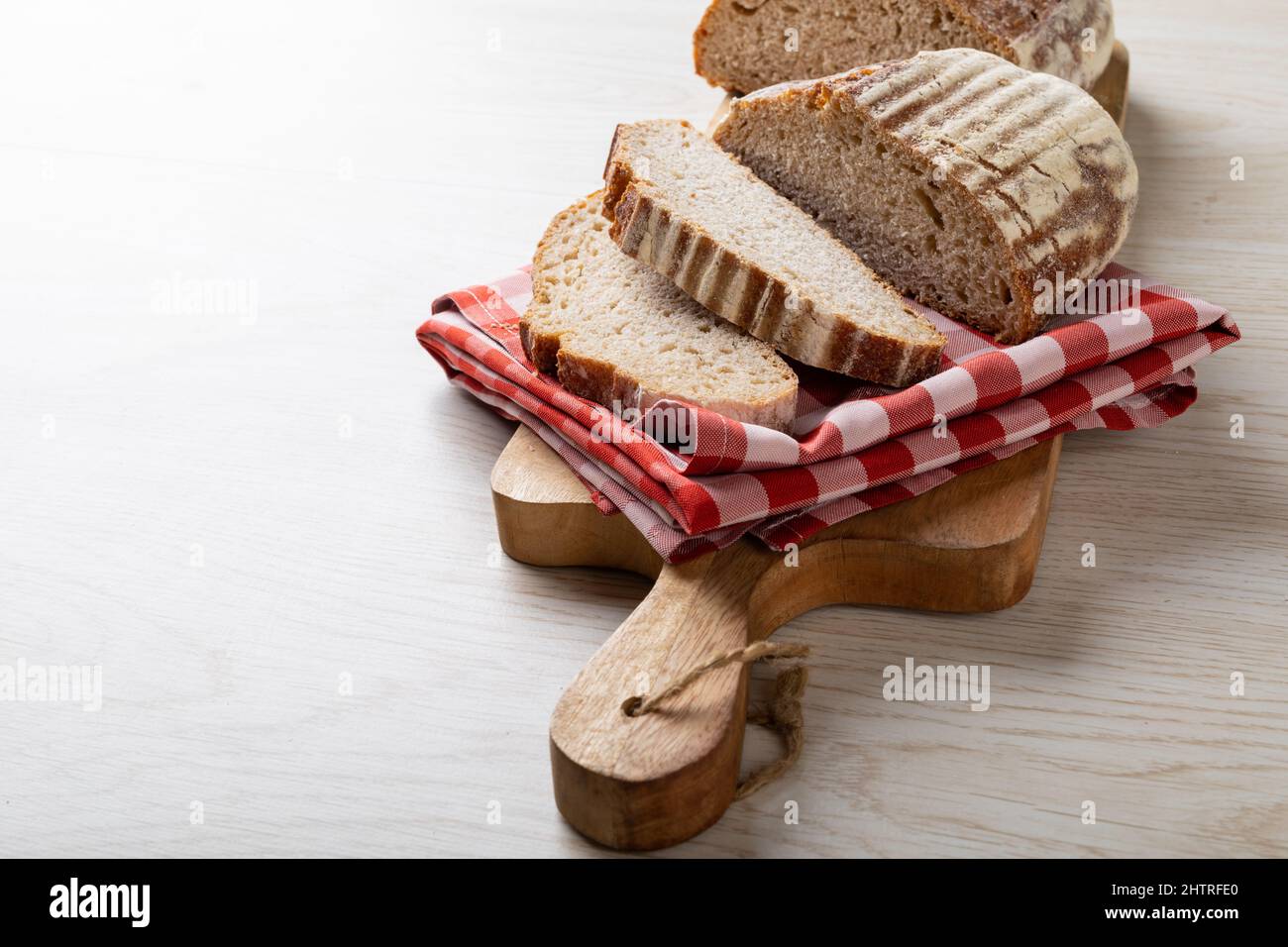 Nahaufnahme von Brotscheiben mit karierter Serviette auf dem Servierbrett mit Platz zum Kopieren Stockfoto