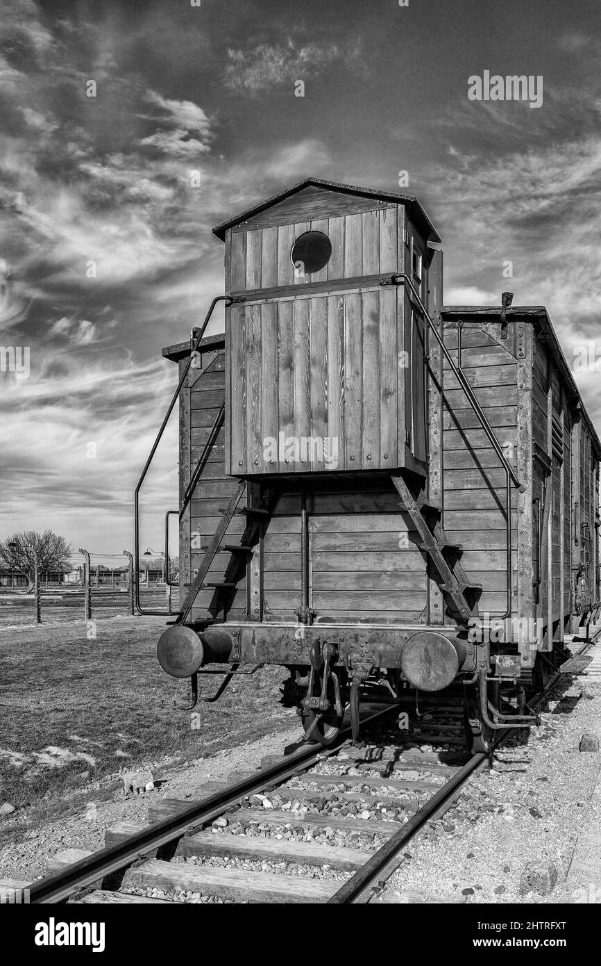 Vertikale Graustufen des hinteren Teils eines alten Eisenbahnwagens an einem sonnigen Tag Stockfoto