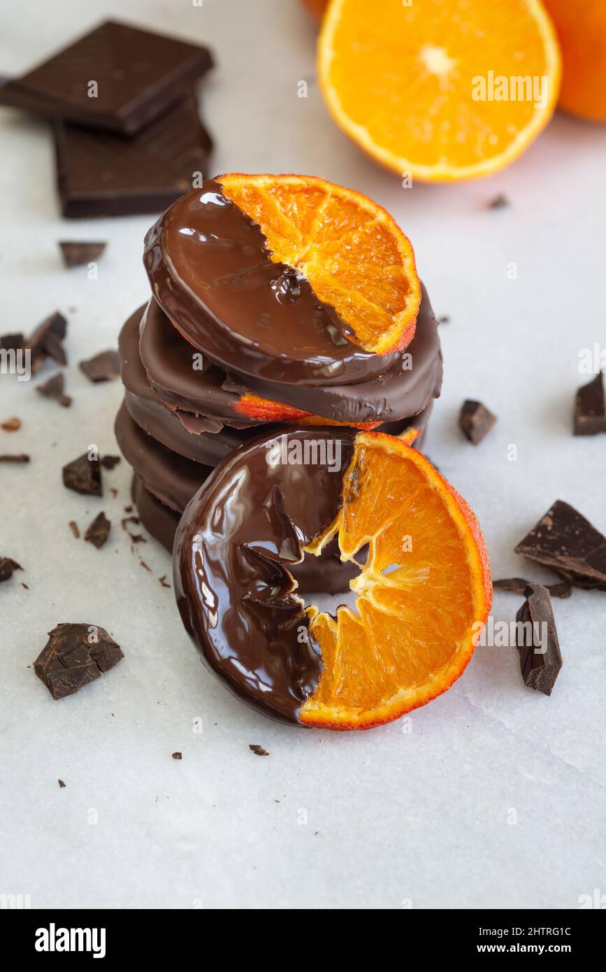 Gestapelte, in Schokolade getauchte kandierte Orangenscheiben. Stockfoto