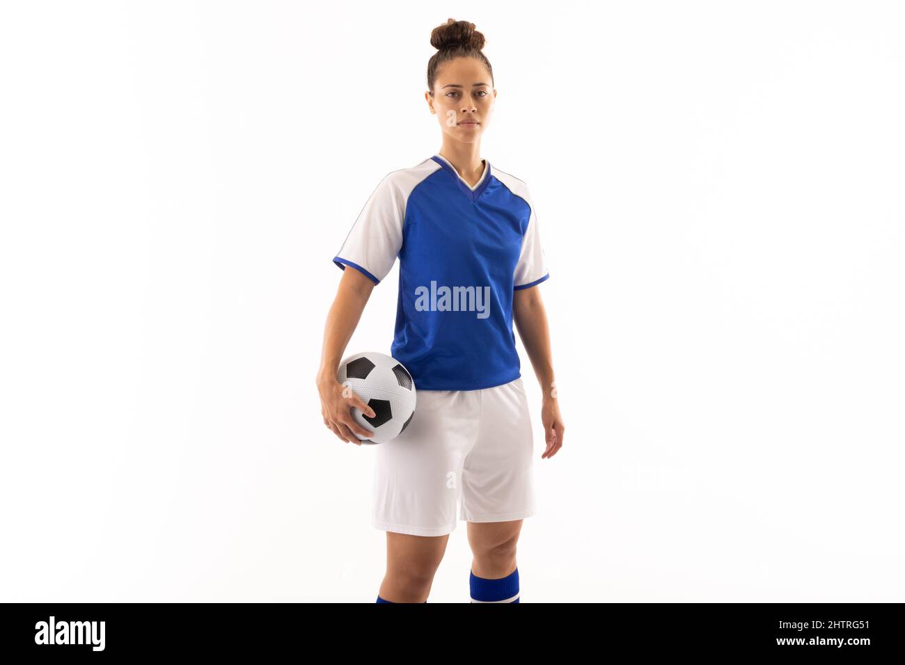Porträt einer jungen Biracial-Fußballspielerin mit Fußballball vor weißem Hintergrund Stockfoto
